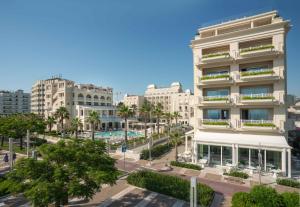 an apartment building in a city with a pool at Hotel Corallo in Riccione