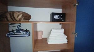 a shelf with towels and a alarm clock and a pile of towels at ADONIS Costinesti in Costinesti +153 photos