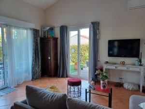 ein Wohnzimmer mit einem Sofa und einem TV in der Unterkunft Maison au calme dans le var in Roquebrune-sur-Argens