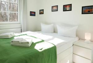 ein weißes Schlafzimmer mit einem Bett mit Handtüchern darauf in der Unterkunft Haus Meeresblick - Ferienwohnung Bernstein (Ref. 128711) in Baabe