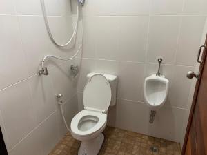 een badkamer met een toilet en een urinoir bij Khao Sok Inn Hostel in Khao Sok