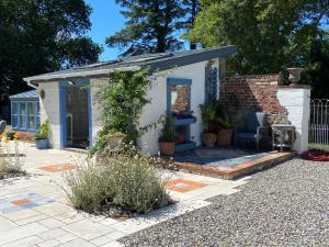 a small white shed with a patio in a yard at Rathjarney Gatelodge in Wexford