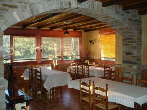 a dining room with two tables and chairs and windows at HOTEL RST. PADORNELO in Padornelo