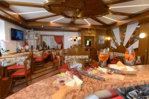 a restaurant with a table with food and wine glasses at Hotel Sole in Passo del Tonale