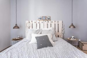 una camera da letto con un grande letto bianco con due lampade di Appartement Le Patio - Stationnement privatif & Tram - proche Montpellier a Saint-Jean-de-Védas