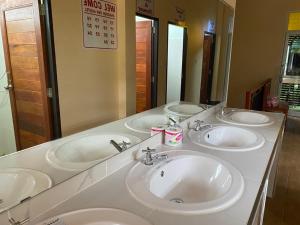 Khao Sok Inn Hostel في خاو سوك: حمام بثلاث مغاسل ومرآة