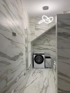 baño con pared de mármol y microondas en Villa Dei Fiori Zambrone, en Zambrone