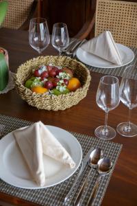 a table with a basket of fruit on a table with glasses at Plataran Bromo in Ngadiwano