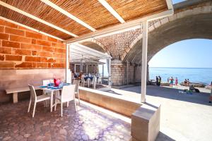 a patio with a table and chairs and the ocean at La casa in riva al mare by LoveSud in Leuca