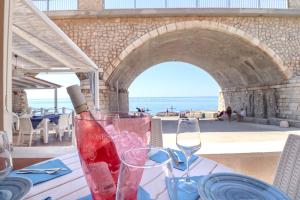 a table with two glasses and a bottle of wine on it at La casa in riva al mare by LoveSud in Leuca