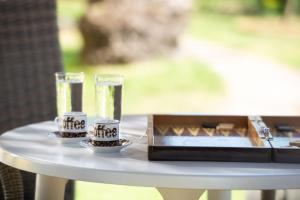 una mesa blanca con dos vasos de agua y cuencos en Anastasia's House, en Toroni