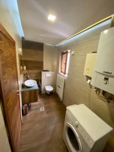 a bathroom with a toilet and a sink and a washing machine at Sarajevo city rent in Sarajevo
