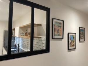 a mirror on a wall with three pictures on it at Le Loft de l hotel Dieu in Villefranche-de-Rouergue