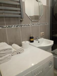 a white bathroom with a sink and a mirror at Apartament Maja2 2 pokoje na Gdańskiej starówce parking w cenie in Gdańsk