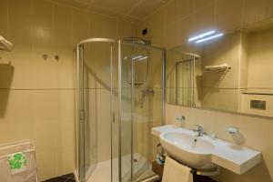 a bathroom with a sink and a shower at Heliconia Park Port Harcourt Hotel and Suites in Port Harcourt