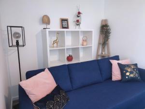 a blue couch with pillows on it in a living room at Cocon avec jardin terrasse privé et parking in Brest