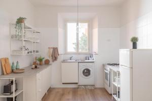 uma cozinha branca com um lavatório e uma máquina de lavar roupa em iFlat Colosseo Modern Apartment em Rudiano