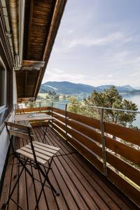 a balcony with chairs and a view of the water at Ferienwohnung Ägerisee in Oberägeri