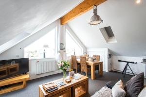 una sala de estar con un sofá y una mesa en The Lighthouse Penthouse, Studio and Holiday Home, en St Ives