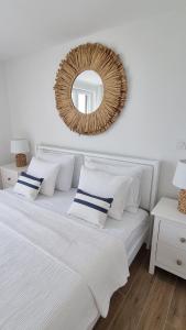 a bedroom with a bed with a mirror on the wall at Salt & Stone Villa in Pag