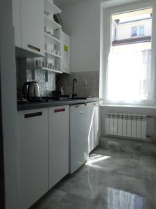 a white kitchen with a sink and a window at Apartament Maja2 2 pokoje na Gdańskiej starówce parking w cenie in Gdańsk