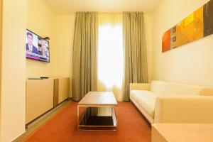 a living room with a couch and a table at Heliconia Park Port Harcourt Hotel and Suites in Port Harcourt