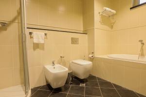a bathroom with a toilet and a sink and a shower at Heliconia Park Port Harcourt Hotel and Suites in Port Harcourt