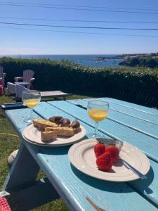 stół piknikowy z dwoma talerzami jedzenia i kieliszkami do wina w obiekcie Cliff cottage w mieście Dunmore East