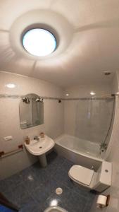 y baño con aseo, lavabo y ducha. en Apartamento Playa de La Atalaya, en Ribadesella