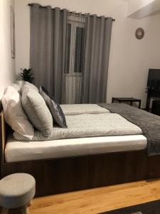a bed with pillows on it in a bedroom at Apartament BAȘAK 2 in Deva