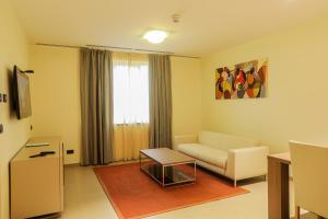 a living room with a couch and a table at Heliconia Park Port Harcourt Hotel and Suites in Port Harcourt