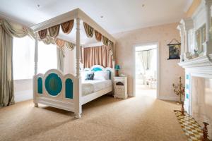 a bedroom with a white bed with a canopy at Enchanted Manor in Niton