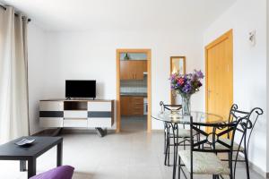 - un salon avec une table et une télévision dans l'établissement Home2Book Cozy Apartment La Lajita, à Lajita