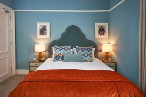 a bedroom with a large bed with blue walls at Hotel du Vin Winchester in Winchester