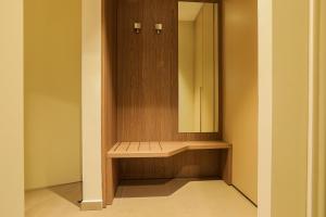 a bathroom with a wooden cabinet with a mirror at Heliconia Park Port Harcourt Hotel and Suites in Port Harcourt