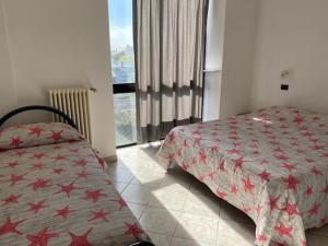 a bedroom with a bed and a window and a bedskirts at Residenza Paradiso in Bellaria-Igea Marina
