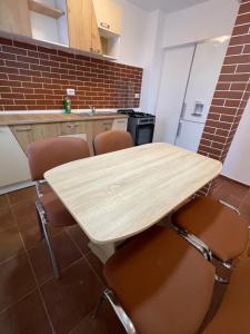 a kitchen with a wooden table and chairs at Apartament SweetHome Piața Unirii in Iaşi