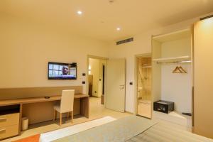a room with a desk and a television on the wall at Heliconia Park Port Harcourt Hotel and Suites in Port Harcourt