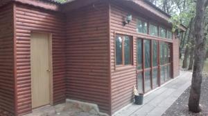 Cette petite cabane en bois dispose d'une porte et de fenêtres. dans l'établissement 1 room in Nikea Park apartaments, aux Sables d'or