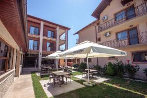 a patio with tables and chairs and an umbrella at Casa Soarelui in 2 Mai