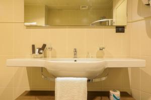 a bathroom with a white sink and a mirror at Heliconia Park Port Harcourt Hotel and Suites in Port Harcourt