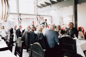 a group of people sitting at tables in a restaurant at Frich's Rudshøgda in Ringsaker