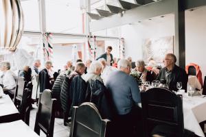 eine Gruppe von Personen, die in einem Restaurant an Tischen sitzen in der Unterkunft Frich's Rudshøgda in Ringsaker