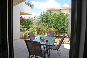 a glass table and chairs on a patio at 2 Bedroom Apartment near the Athens Airport, Spata in Spáta