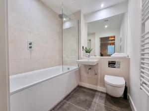 a white bathroom with a toilet and a sink at Stunning 4-bedroom Townhouse with Free Parking in Manchester