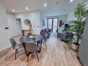 a living room with a table and chairs at Stunning 4-bedroom Townhouse with Free Parking in Manchester