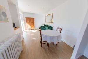 a dining room with a white table and chairs at Le 74 in Avranches