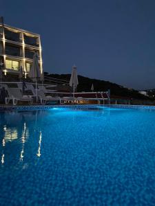 a large swimming pool at a resort at night at Apartments Komina in Utjeha