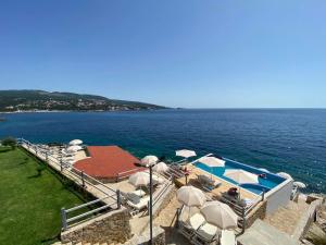 a group of chairs and a swimming pool in the water at Apartments Komina in Utjeha