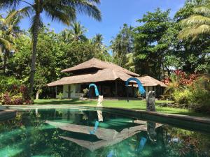 een resort met een zwembad en een hut bij Cape Gulah Bali in Tejakula